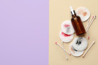 Photo of Dirty cotton pads, swabs and makeup removal product on color background, flat lay. Space for text