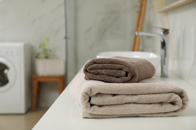 Photo of Stack of clean towels on bathroom countertop