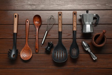 Photo of Set of different kitchen utensils on wooden table, flat lay