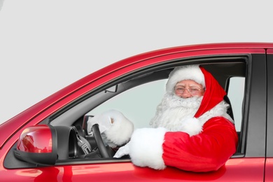 Authentic Santa Claus driving red car, view from outside
