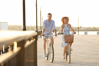 Photo of Happy couple riding bicycles outdoors on summer day