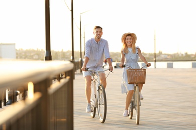 Happy couple riding bicycles outdoors on summer day