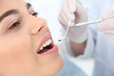 Photo of Dentist examining patient's teeth in modern clinic