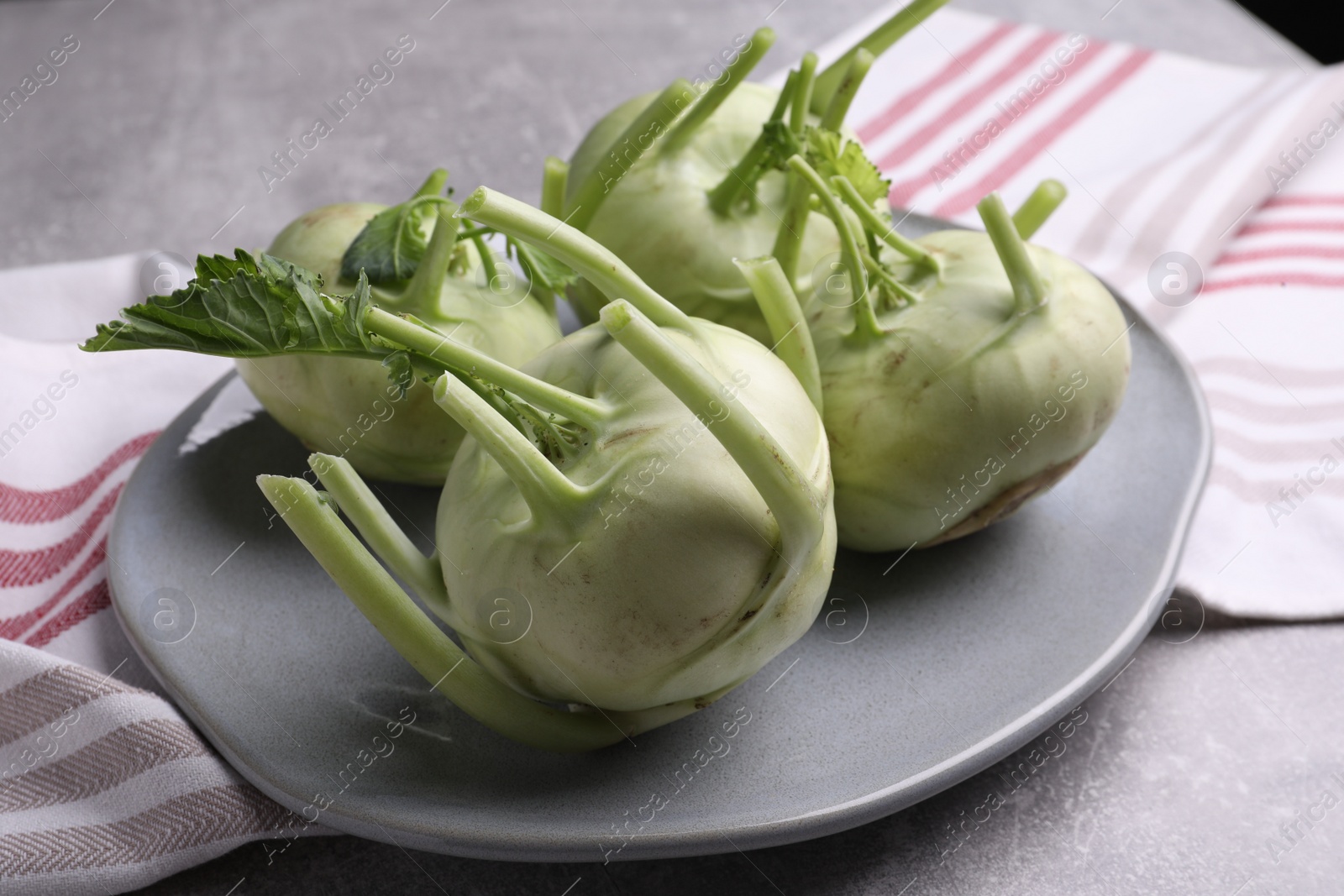 Photo of Whole ripe kohlrabi plant on grey table