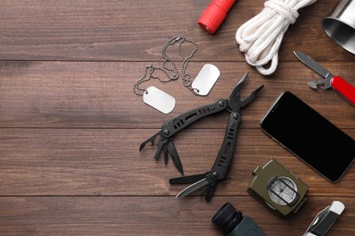 Photo of Flat lay composition with compact portable multitool and accessories on wooden background. Space for text