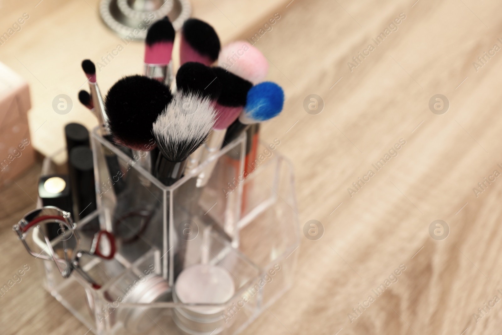 Photo of Organizer with cosmetic products for makeup on table. Space for text