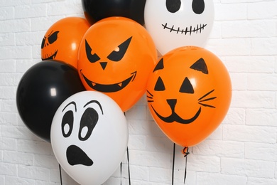 Color balloons for Halloween party against white brick wall