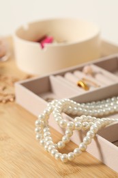 Photo of Jewelry boxes with many different accessories on wooden table, closeup