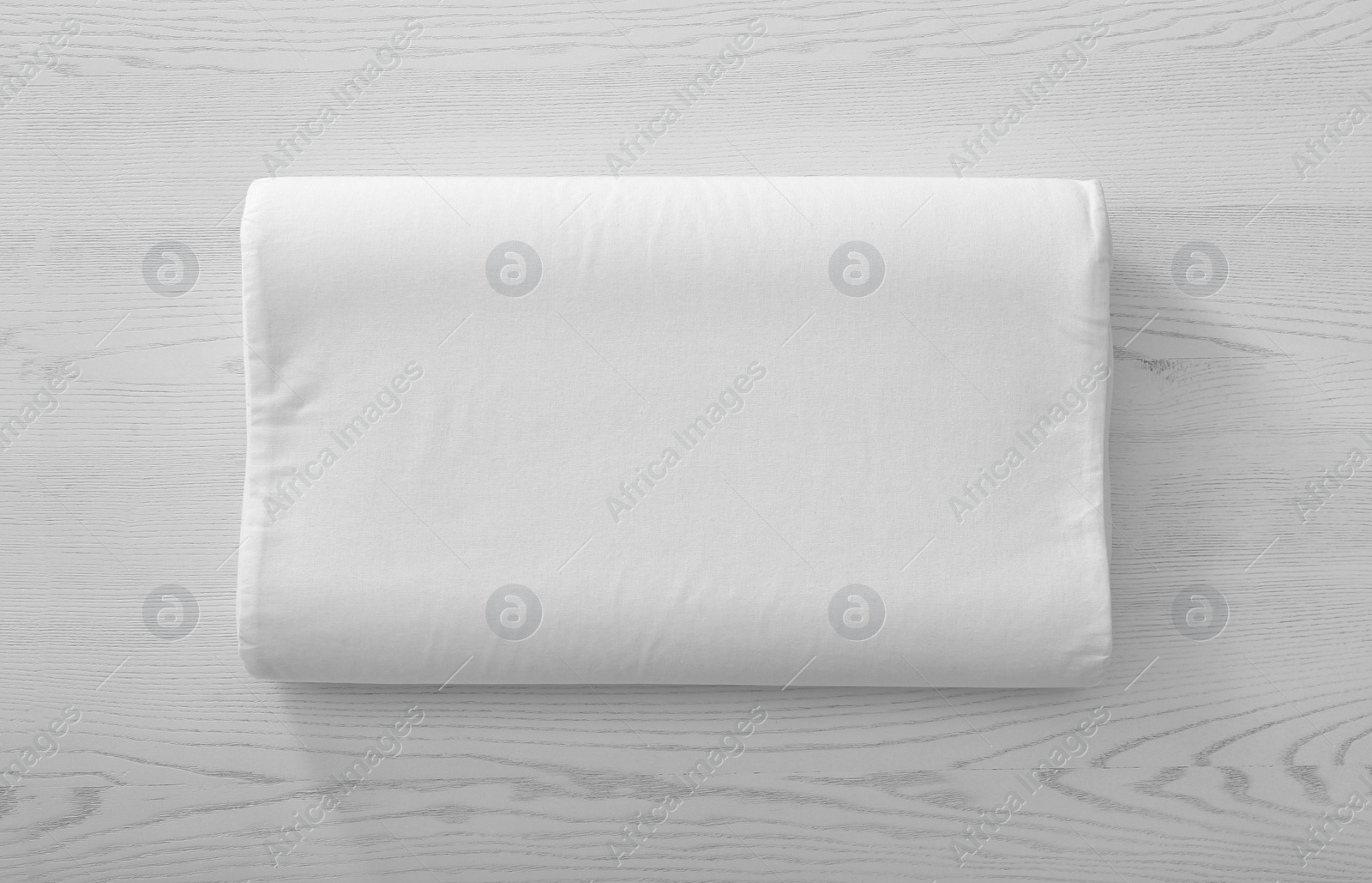 Photo of Soft bed pillow on wooden background, top view