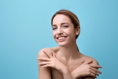 Photo of Beautiful young woman with silky skin on color background