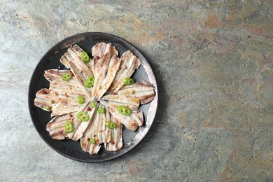 Tasty pickled anchovies with spices on textured table, top view. Space for text