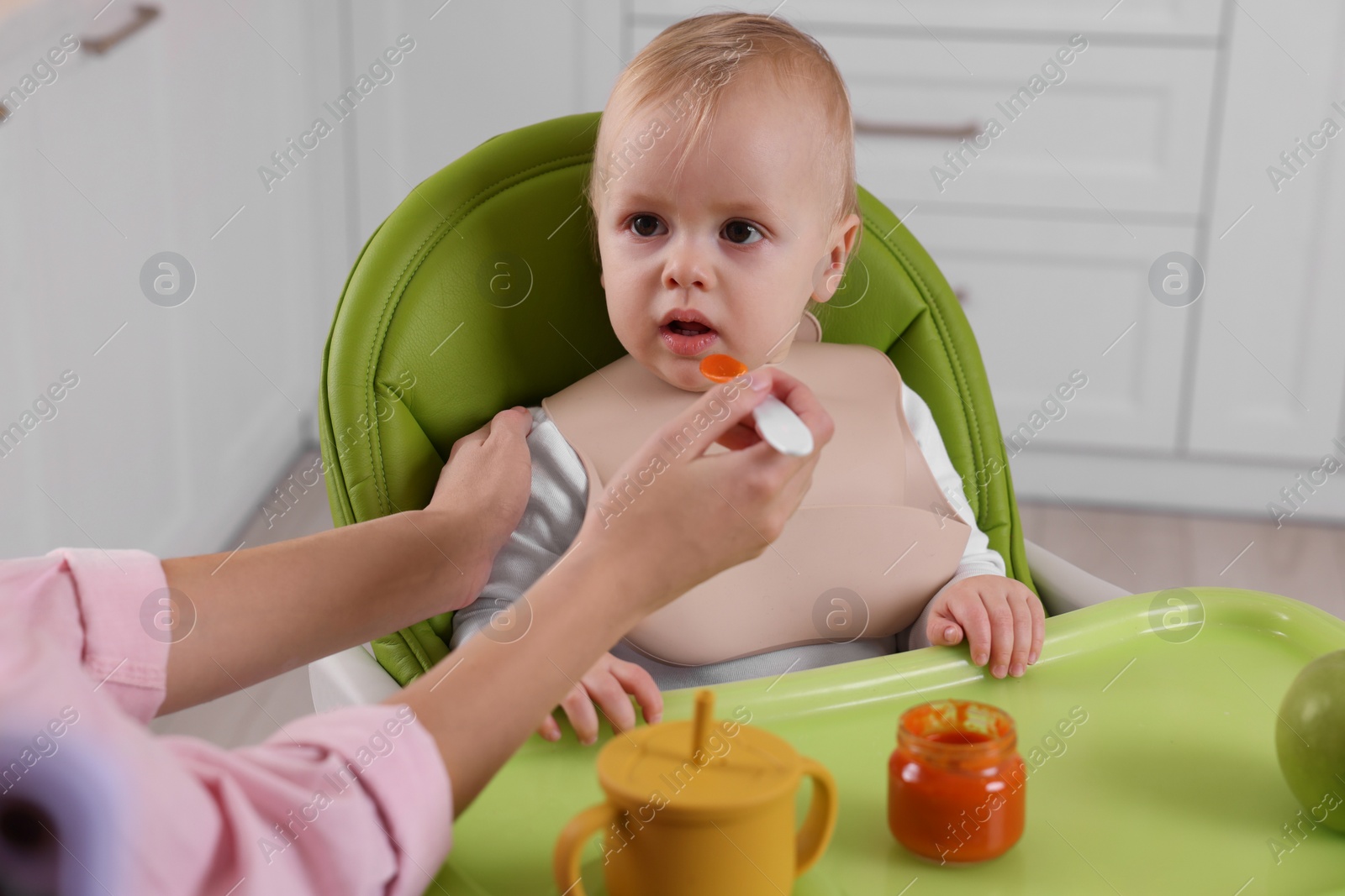 Photo of Mother feeding her cute little baby with healthy food at home