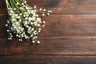 Photo of Fresh spring flowers on wooden background, top view