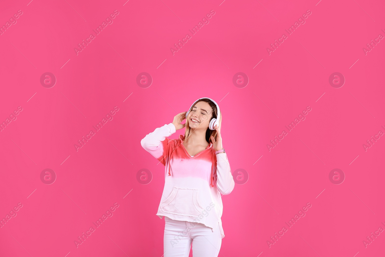 Photo of Teenage girl listening to music with headphones on color background
