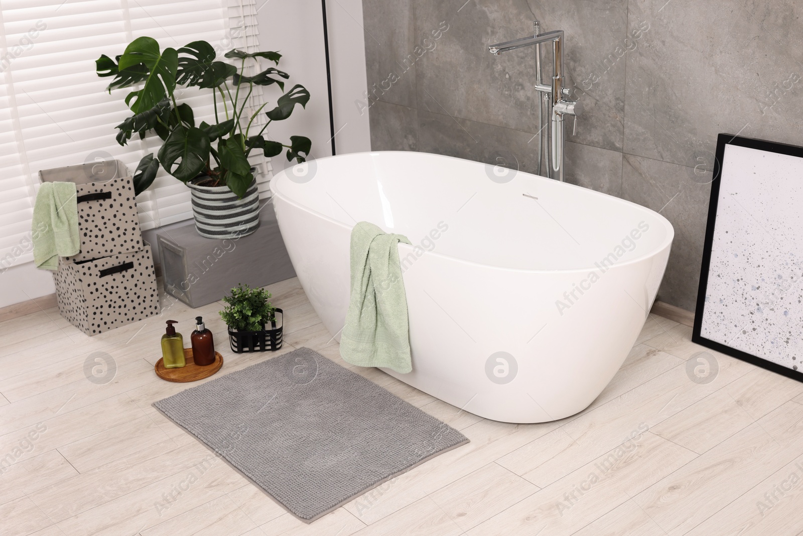 Photo of Stylish bathroom interior with soft bath mat and tub