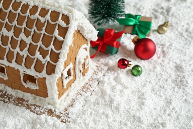 Photo of Beautiful gingerbread house decorated with icing and Christmas balls on snow
