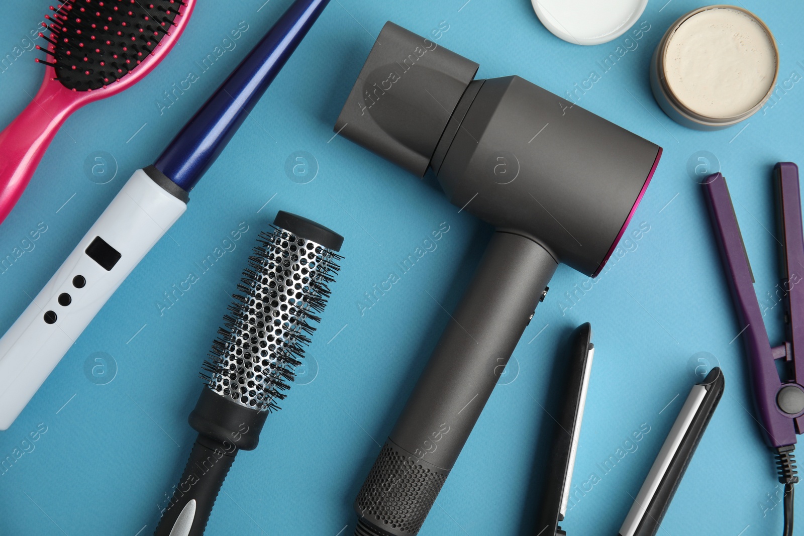 Photo of Flat lay composition with hairdressing equipment on light blue background