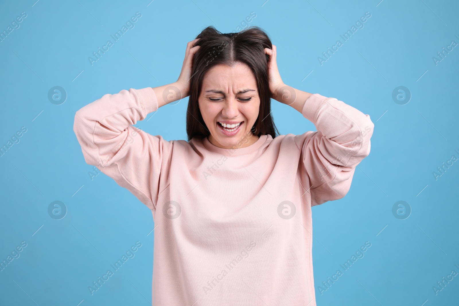 Photo of Portrait of stressed young woman on light blue background