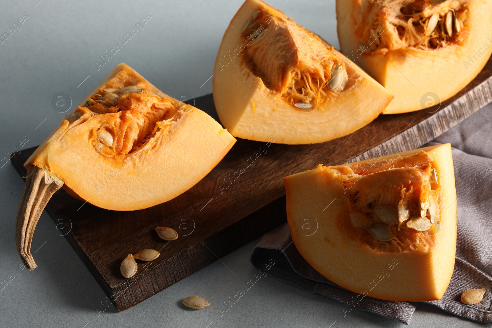 Photo of Cut fresh ripe pumpkin on grey background