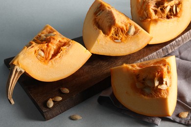 Photo of Cut fresh ripe pumpkin on grey background