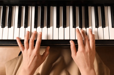 Photo of Young woman playing piano, above view. Music lesson