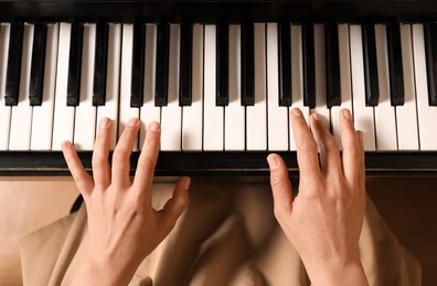 Young woman playing piano, above view. Music lesson