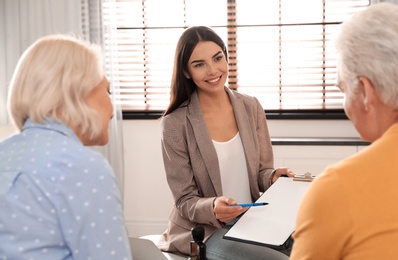 Photo of Female notary working with mature couple in office