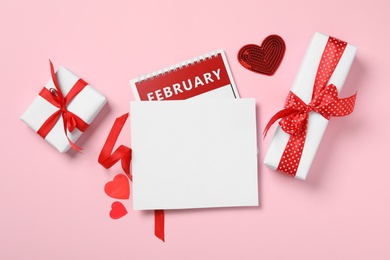 Photo of Flat lay composition with blank card on pink background, space for text. Valentine's Day celebration