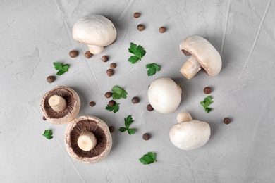 Flat lay composition with fresh champignon mushrooms on grey background