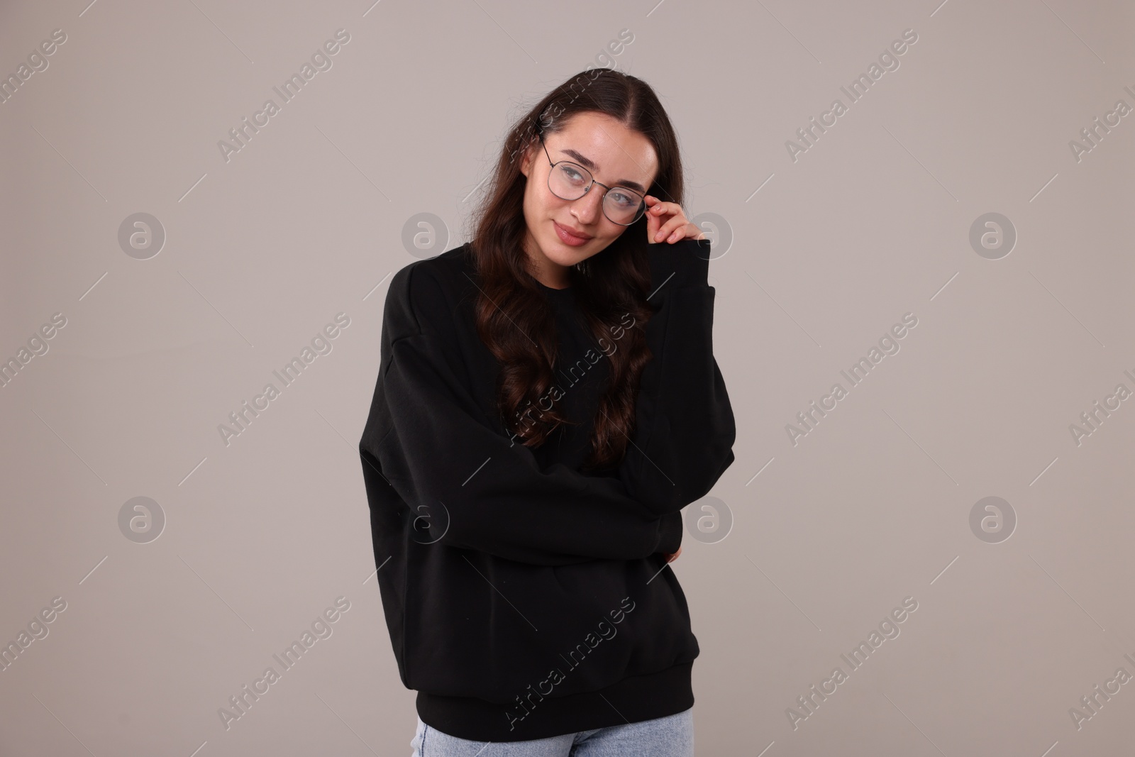 Photo of Beautiful young woman in stylish warm sweater on grey background