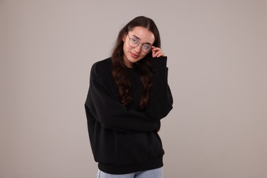 Photo of Beautiful young woman in stylish warm sweater on grey background