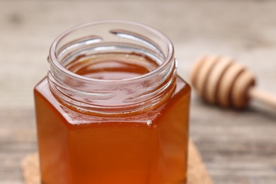 Photo of Sweet honey in jar on table, closeup