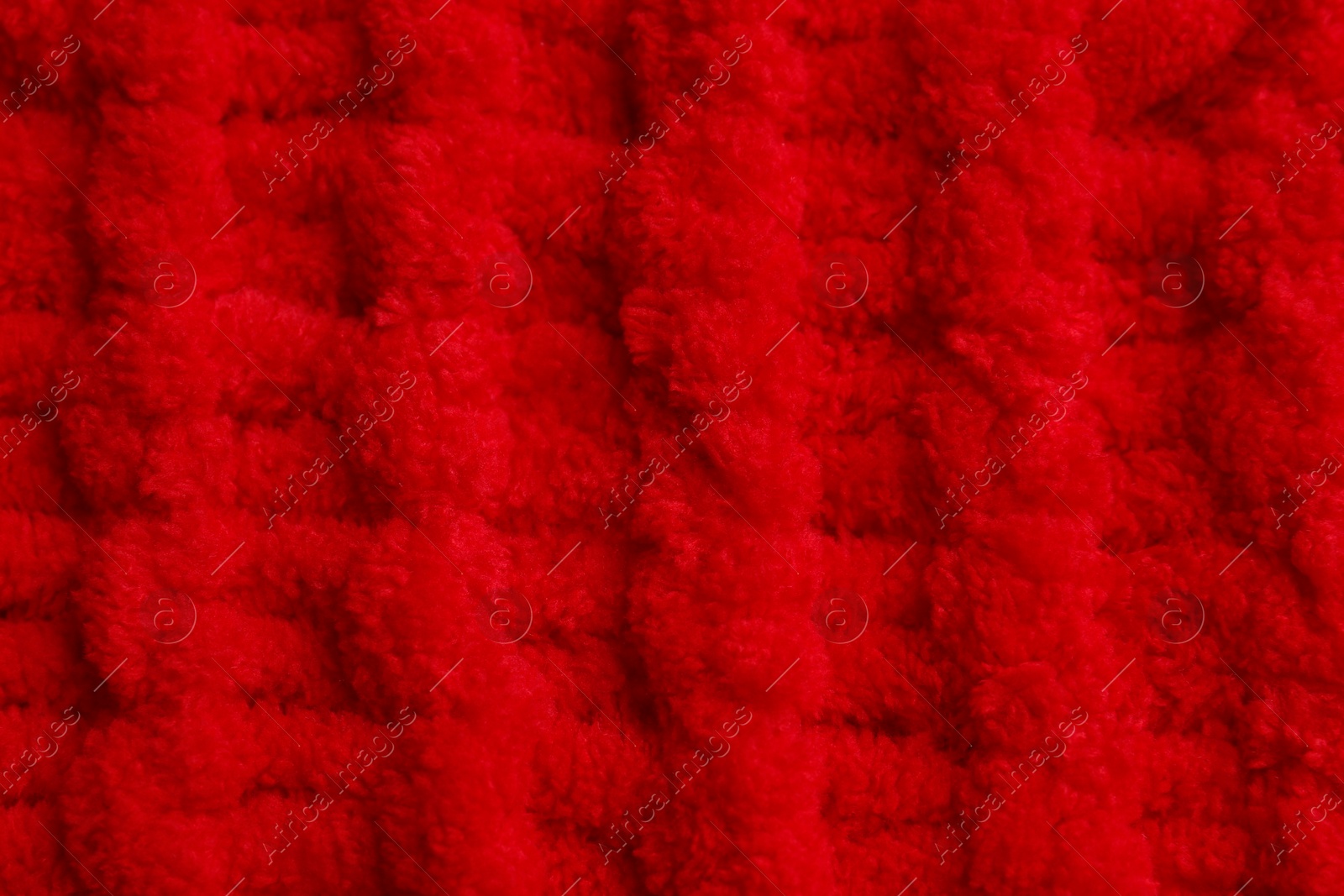 Photo of Soft red knitted fabric as background, top view