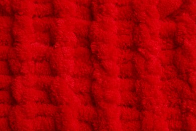 Soft red knitted fabric as background, top view
