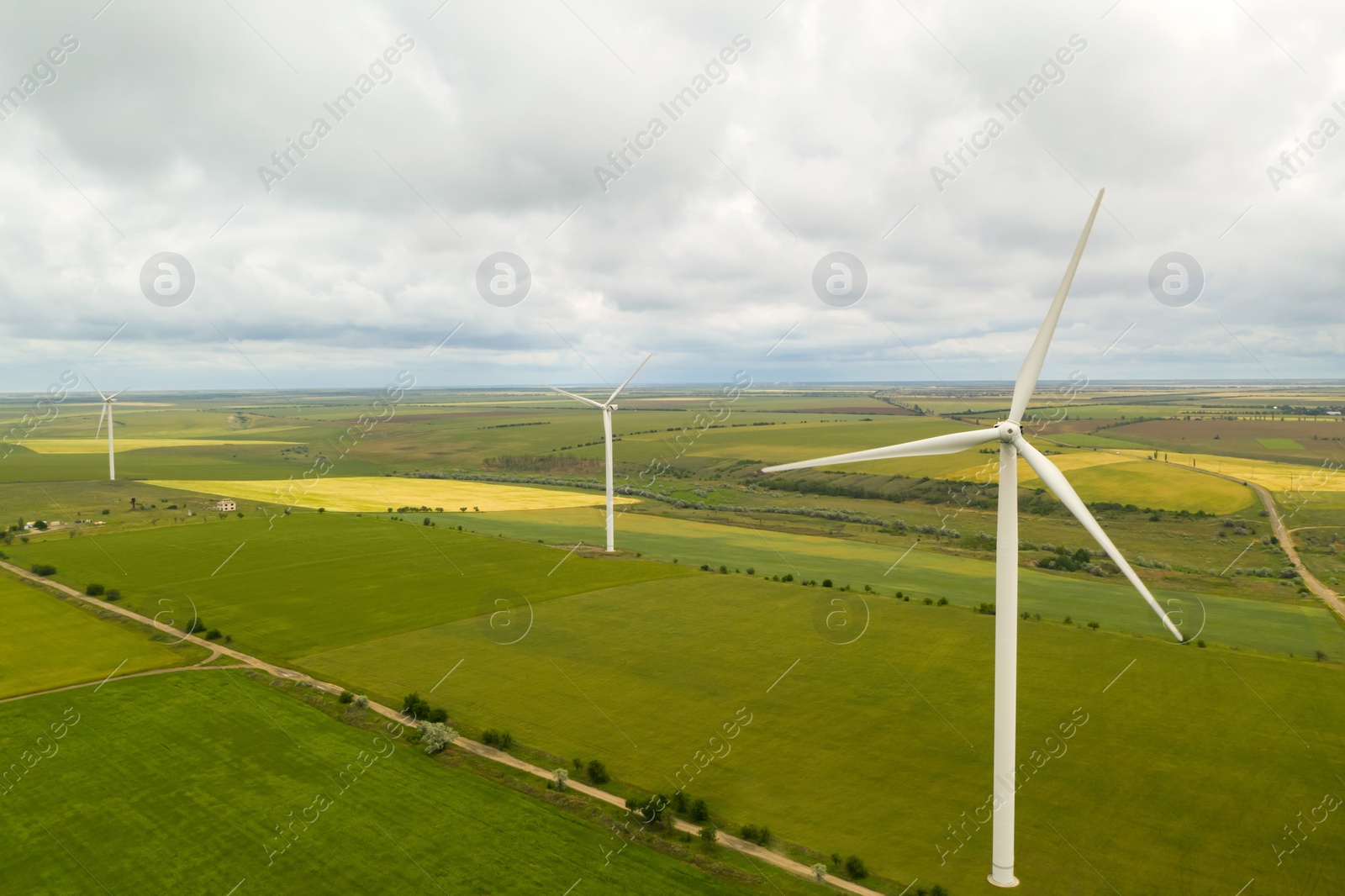 Image of Aerial view of wind turbines in field on cloudy day