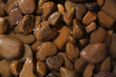 Photo of Beautiful pebbles in water as background, top view