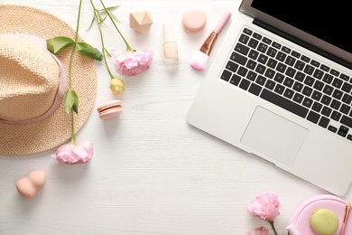 Flat lay composition with laptop, makeup products and accessories on white wooden table. Fashion blogger