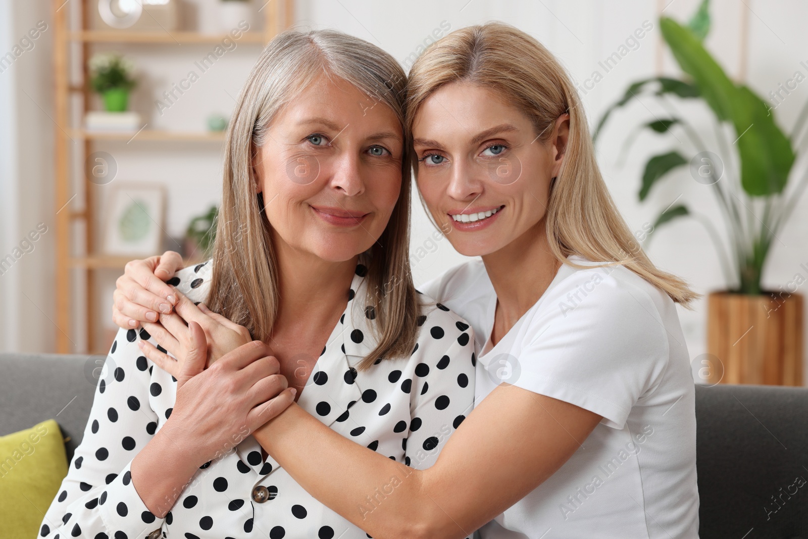 Photo of Happy mature mother and her daughter hugging at home