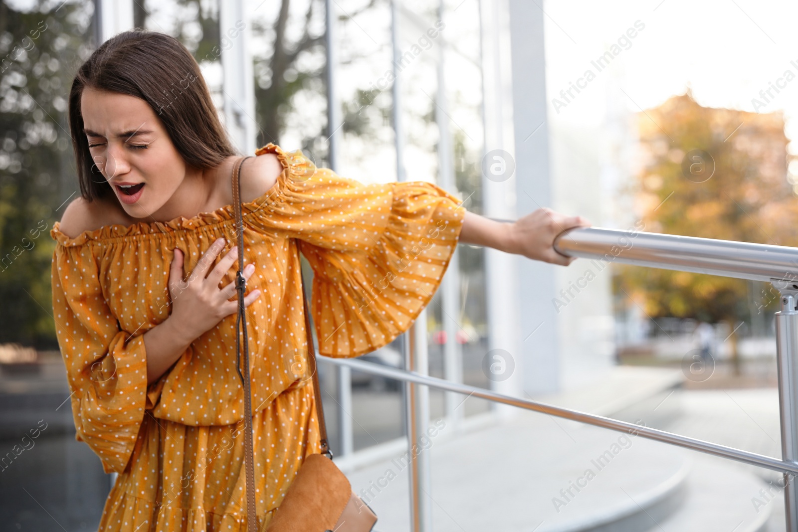 Photo of Young woman having heart attack on city street