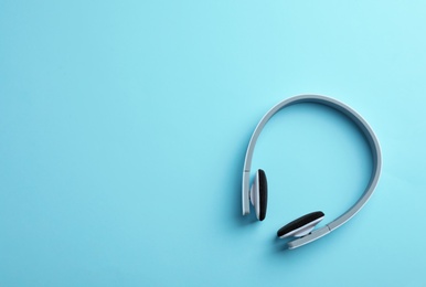 Photo of Wireless headphones on color background, top view. Space for text