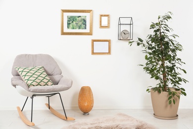 Photo of Stylish living room interior with ficus and rocking chair near white wall