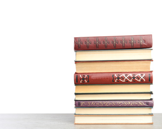 Photo of Stack of old vintage books on stone table against white background