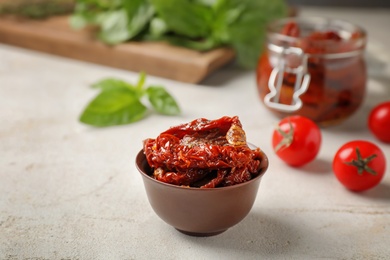 Photo of Dried tomatoes in bowl on table. Healthy snack