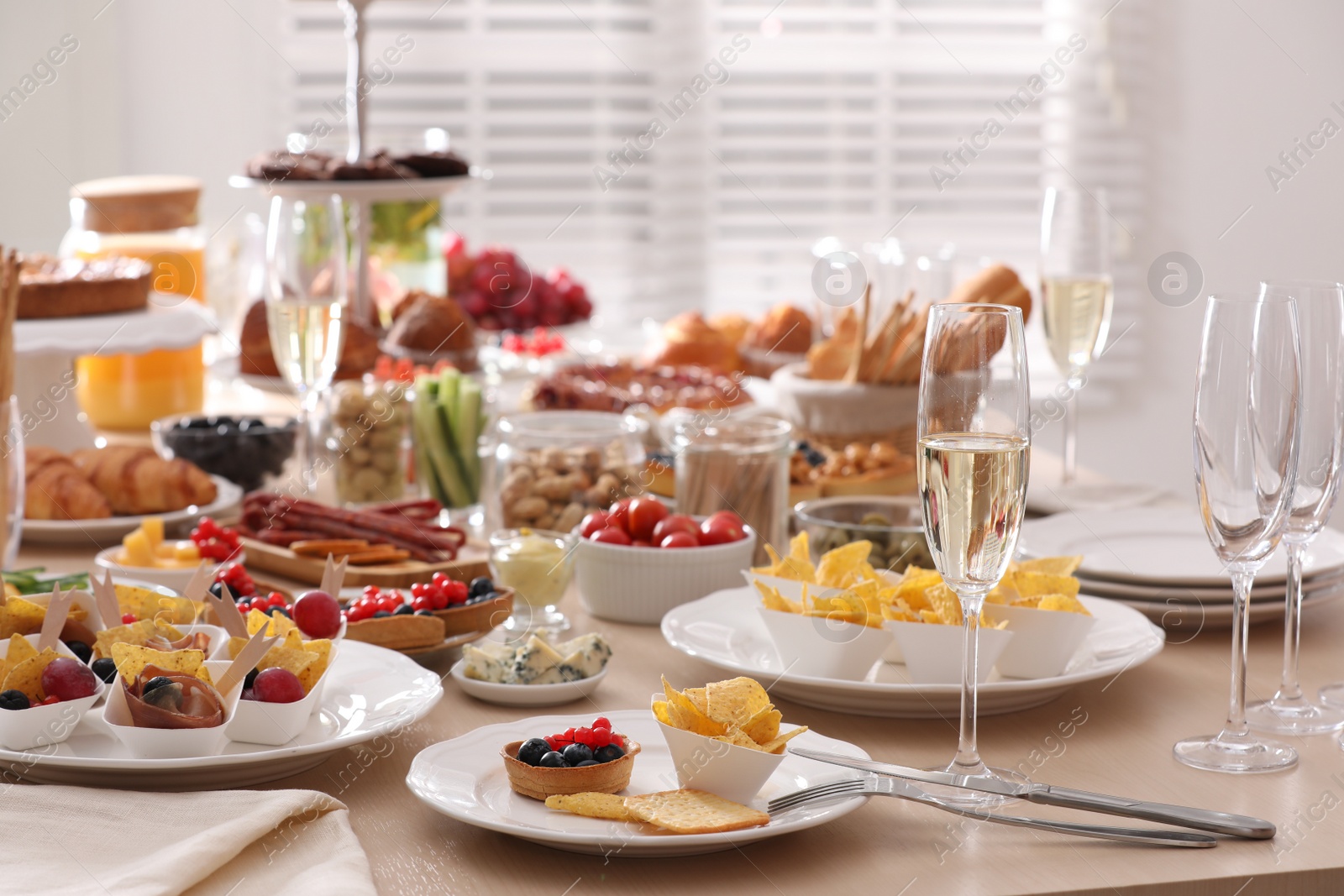 Photo of Variety of snacks on wooden table in buffet style indoors