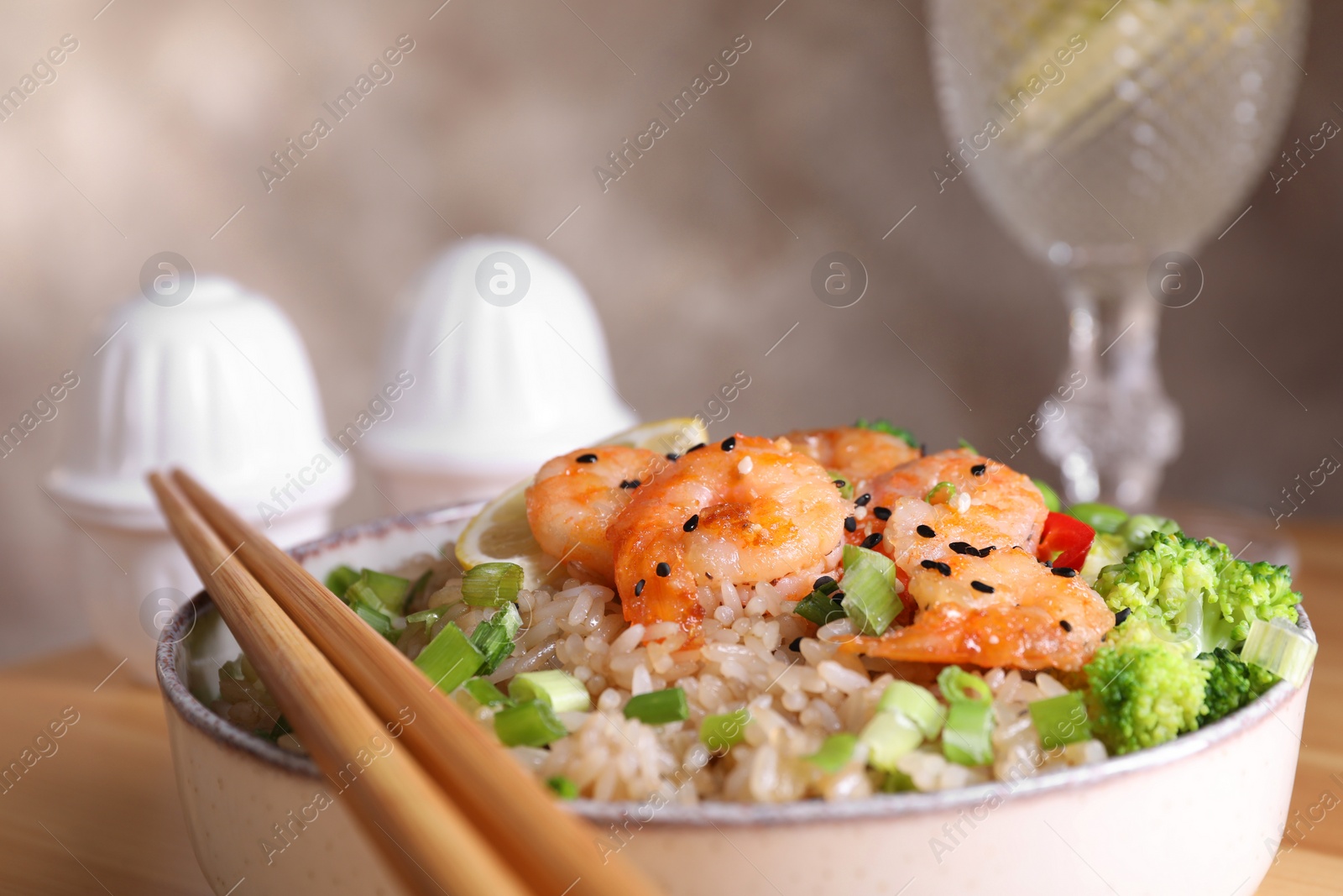 Photo of Tasty rice with shrimps and vegetables in bowl, closeup. Space for text