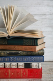 Photo of Stack of hardcover books on wooden table against white  background