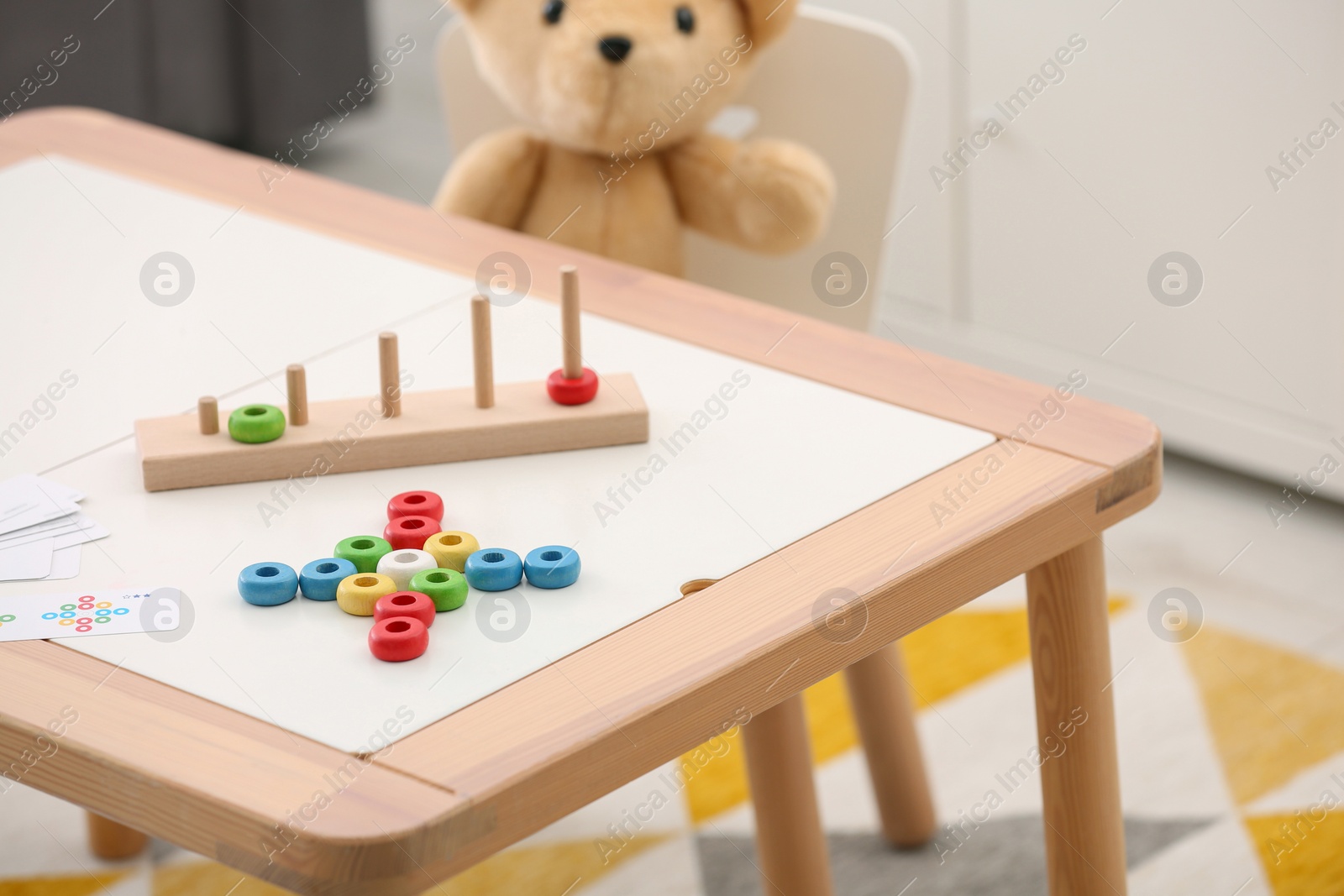 Photo of Stacking and counting game on table indoors. Educational toy for motor skills development