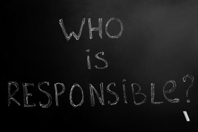 Photo of Question Who Is Responsible and chalk piece on black background