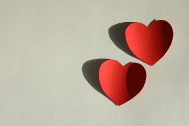 Photo of Paper hearts on light grey background, flat lay. Space for text