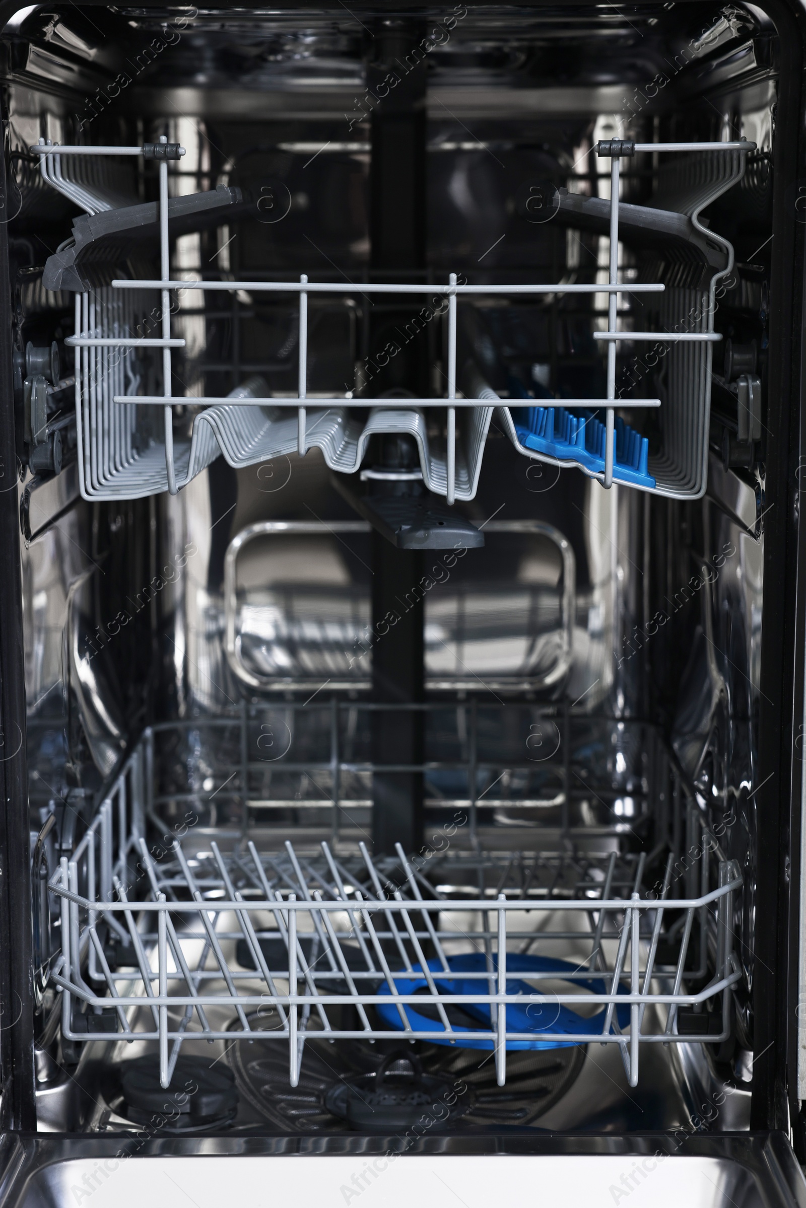 Photo of Open clean empty dishwasher machine, closeup. Home appliance